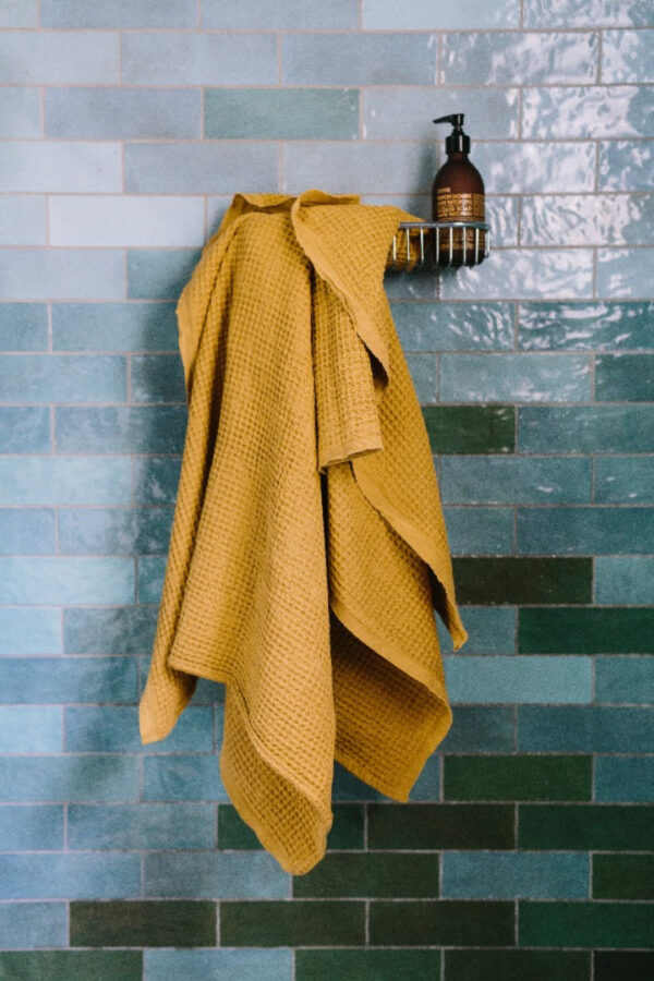 ochre waffle weave towel hanging in shower