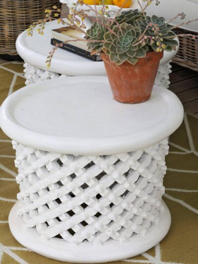white bamileke stool with a potplant on top