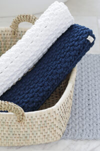 crochet bath mat rolled up in basket