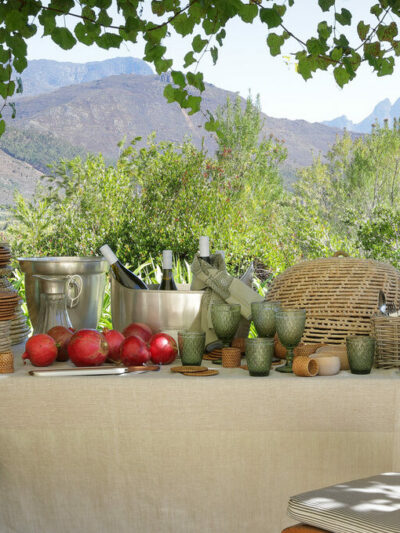 Lifestlyle table setting with glassware, rattan baskets and placemats